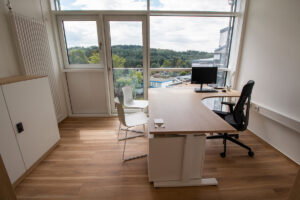 Büro mit Eckschreibtisch, Schrank, Stühle, Schreibtischstuhl